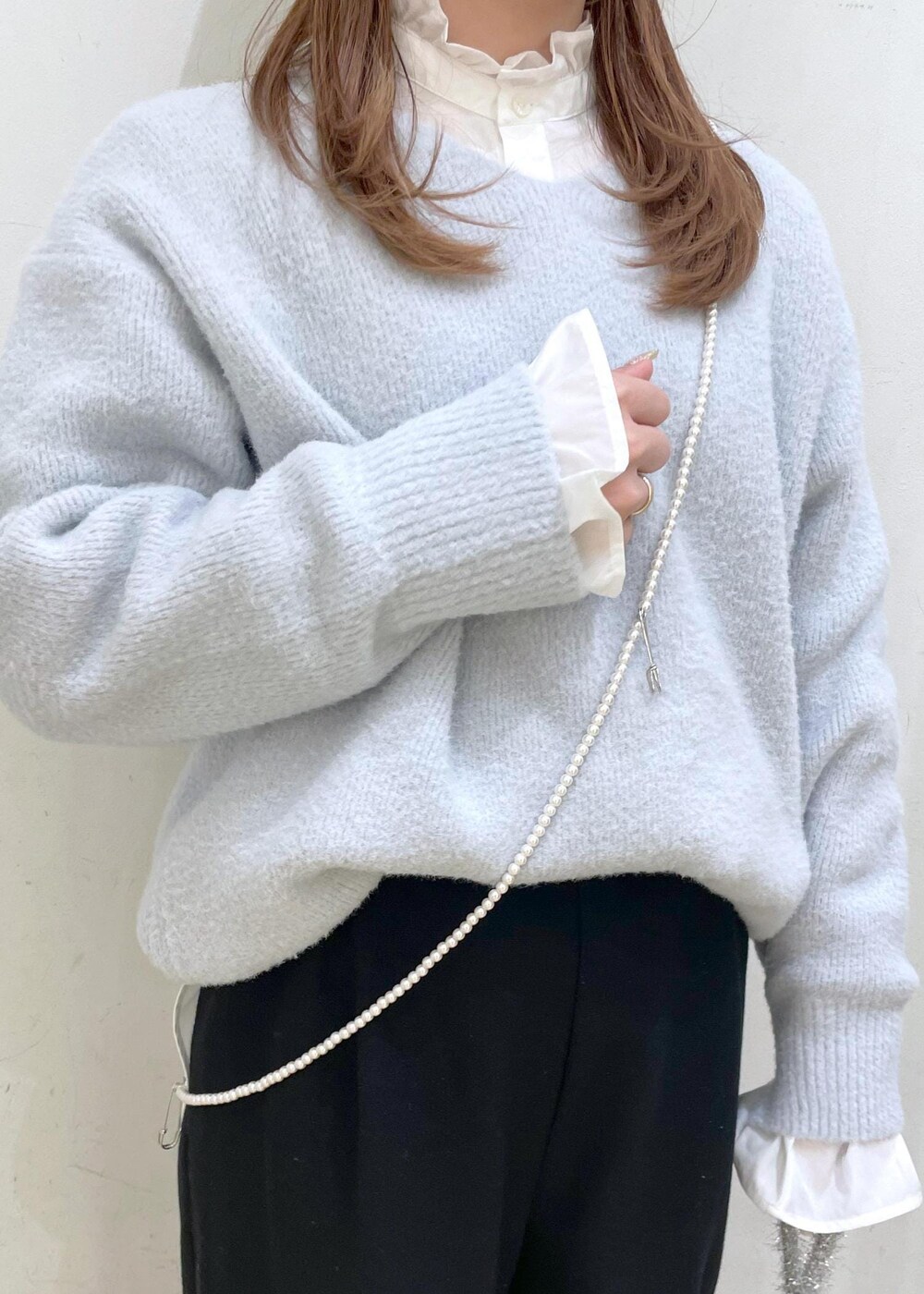 ホワイト系のシャツ/ブラウス、ブルー系のニット/セーター、ブラック系のその他パンツを着用したレディースの冬コーディネートの5枚目の写真