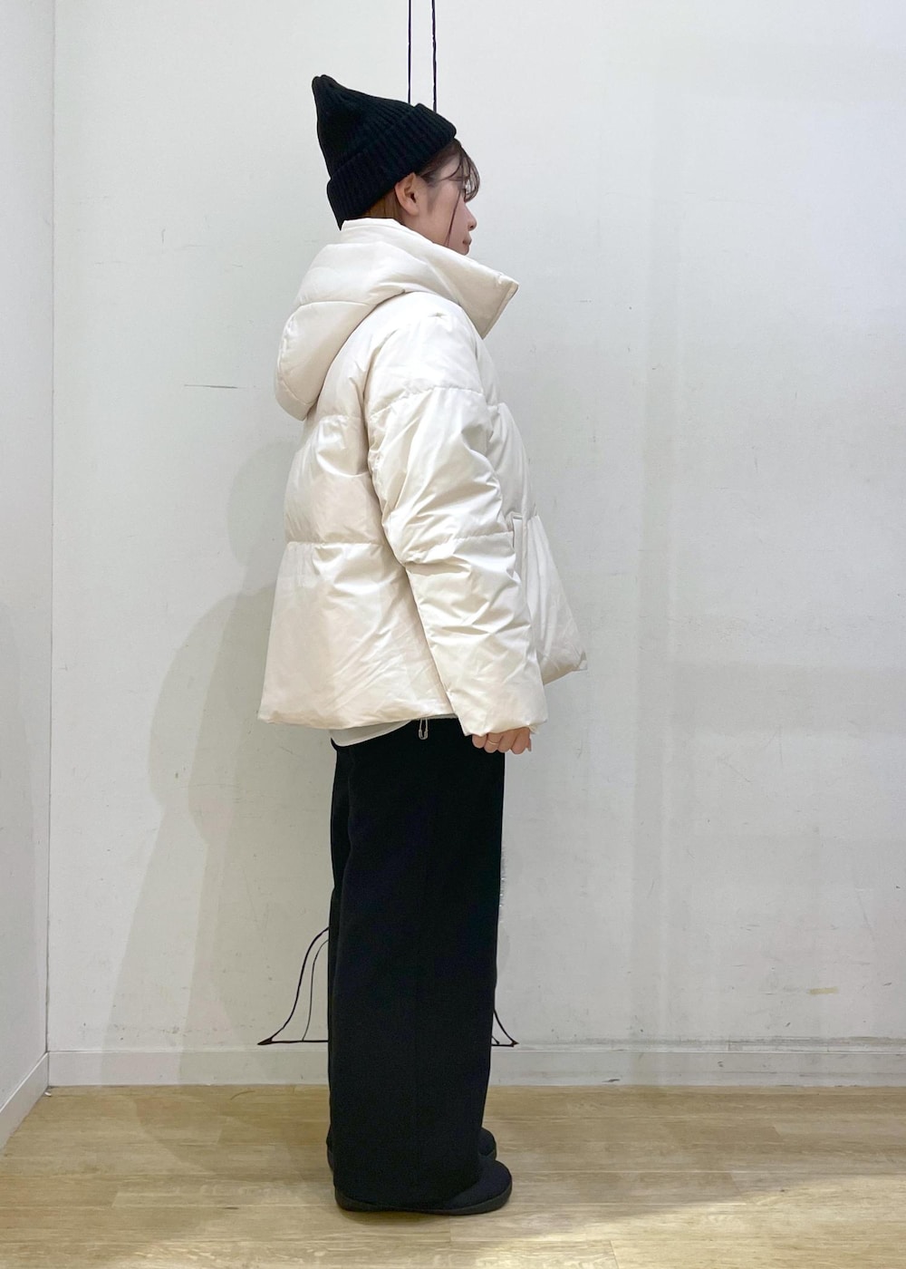 ベージュ系のダウンジャケット/コート、シルバー系のショルダーバッグ、ブルー系のニット/セーターを着用したレディースの冬コーディネートの2枚目の写真