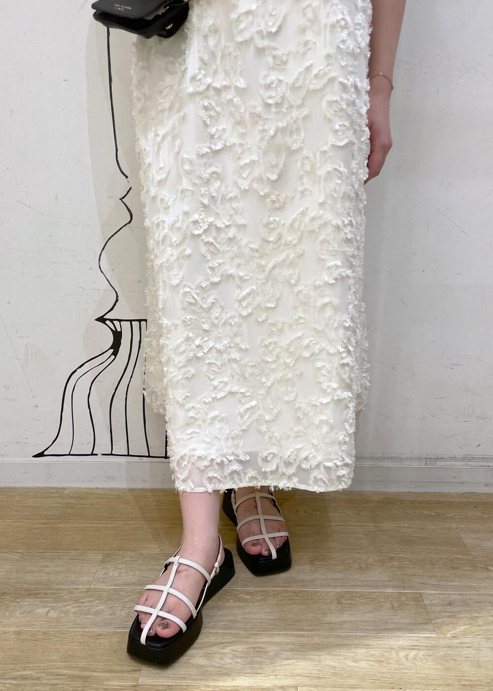 ホワイト系のサンダル、ホワイト系のワンピース、ブラック系のショルダーバッグを着用したレディースの夏コーディネートの6枚目の写真