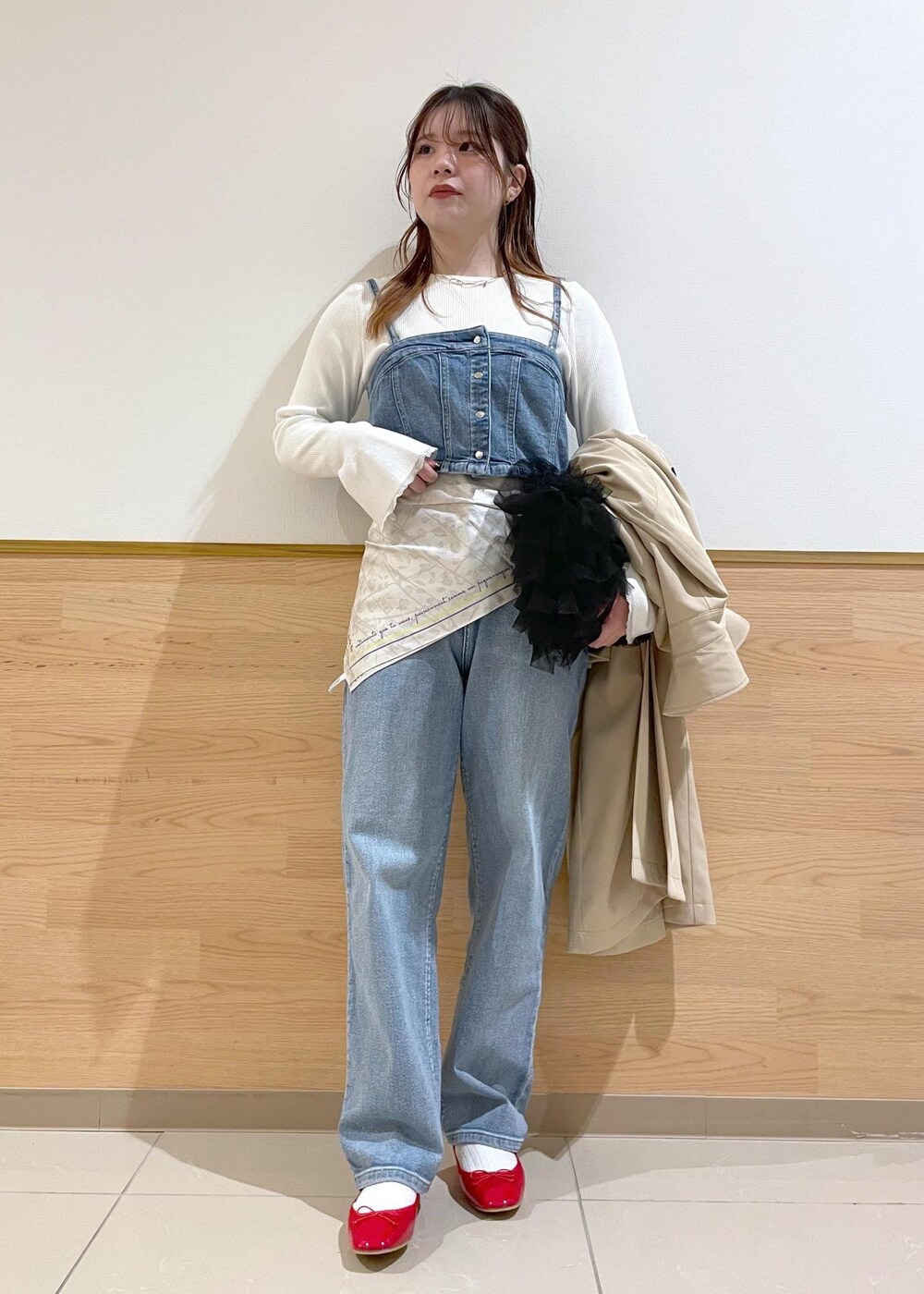 ブルー系のベスト、ホワイト系のニット/セーター、ベージュ系のトレンチコートを着用したレディースの春コーディネートの4枚目の写真