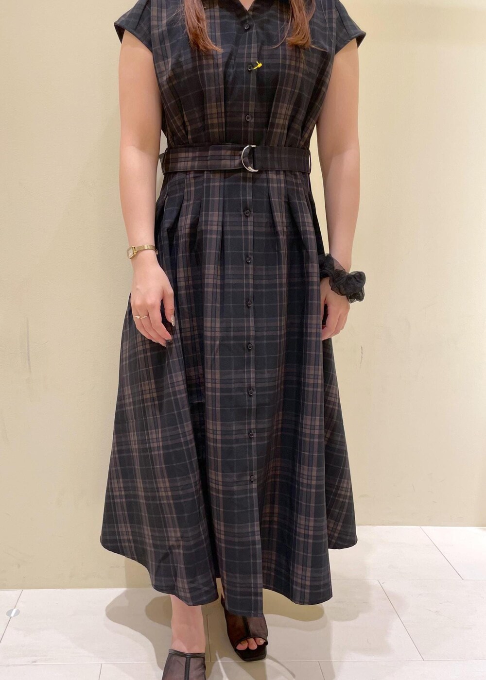 ブラック系のパンプス、ブラック系のワンピース、ベージュ系のボストンバッグを着用したレディースの夏コーディネートの7枚目の写真