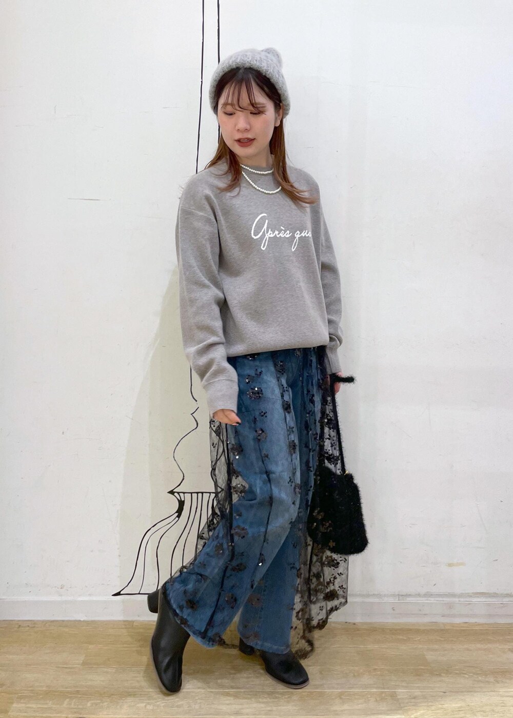 ブラック系のスカート、グレー系のニット/セーター、ブラック系のブーツを着用したレディースの秋コーディネートの9枚目の写真