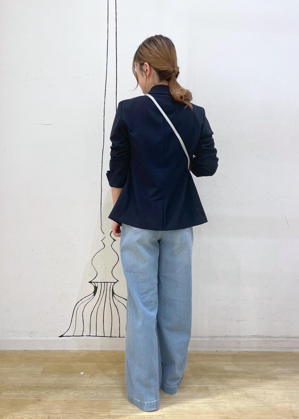 ブルー系のデニムパンツ、シルバー系のサンダル、ホワイト系のニット/セーターを着用したレディースの夏コーディネートの2枚目の写真