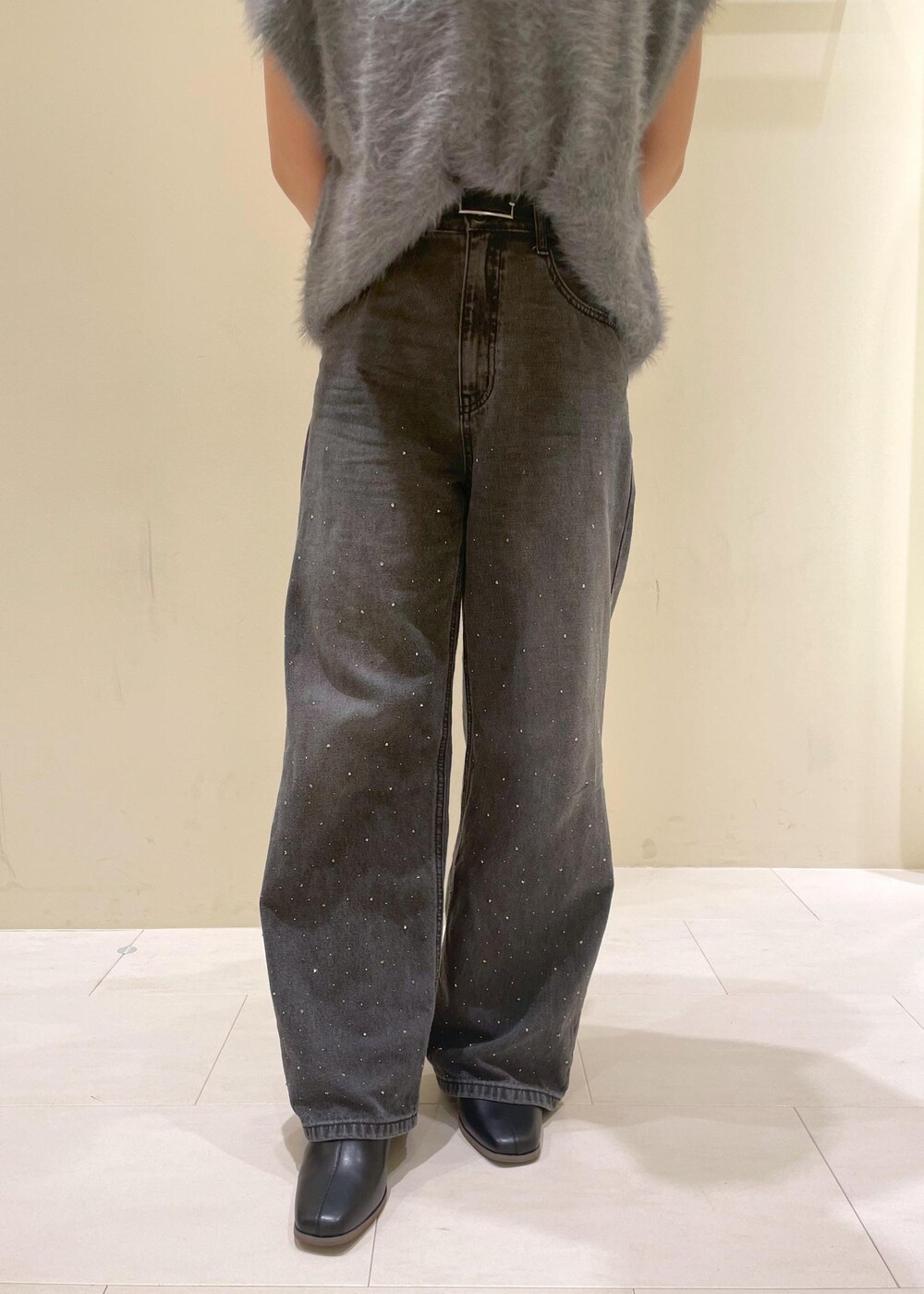 ホワイト系のタンクトップ、グレー系のベスト、ブラック系のブーツを着用したレディースの秋コーディネートの8枚目の写真