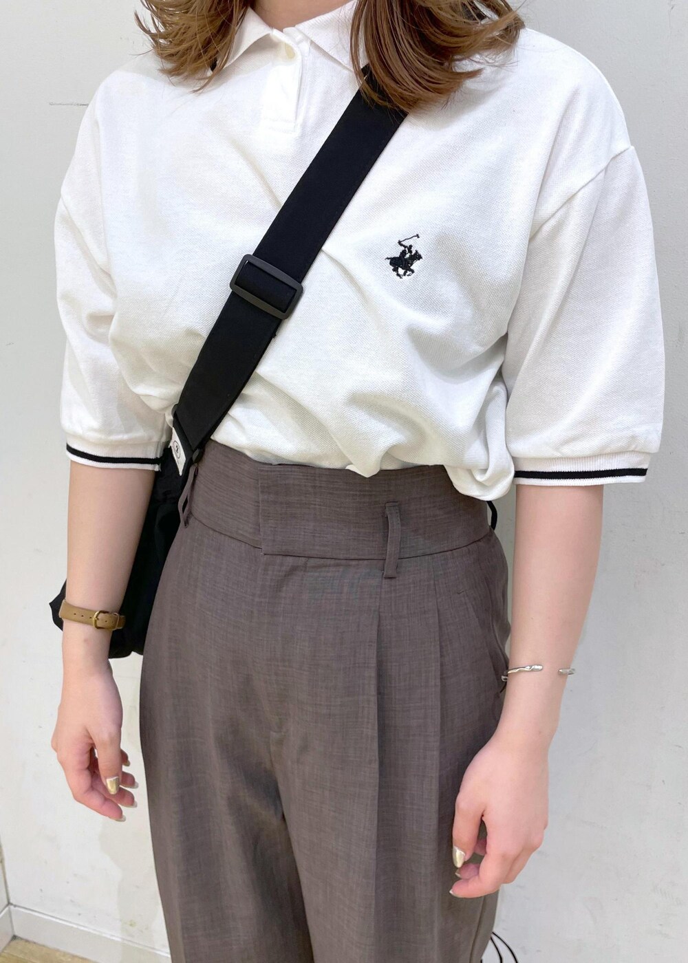 ブラウン系のその他パンツ、ブラック系のサンダル、ホワイト系のポロシャツを着用したレディースの春コーディネートの4枚目の写真