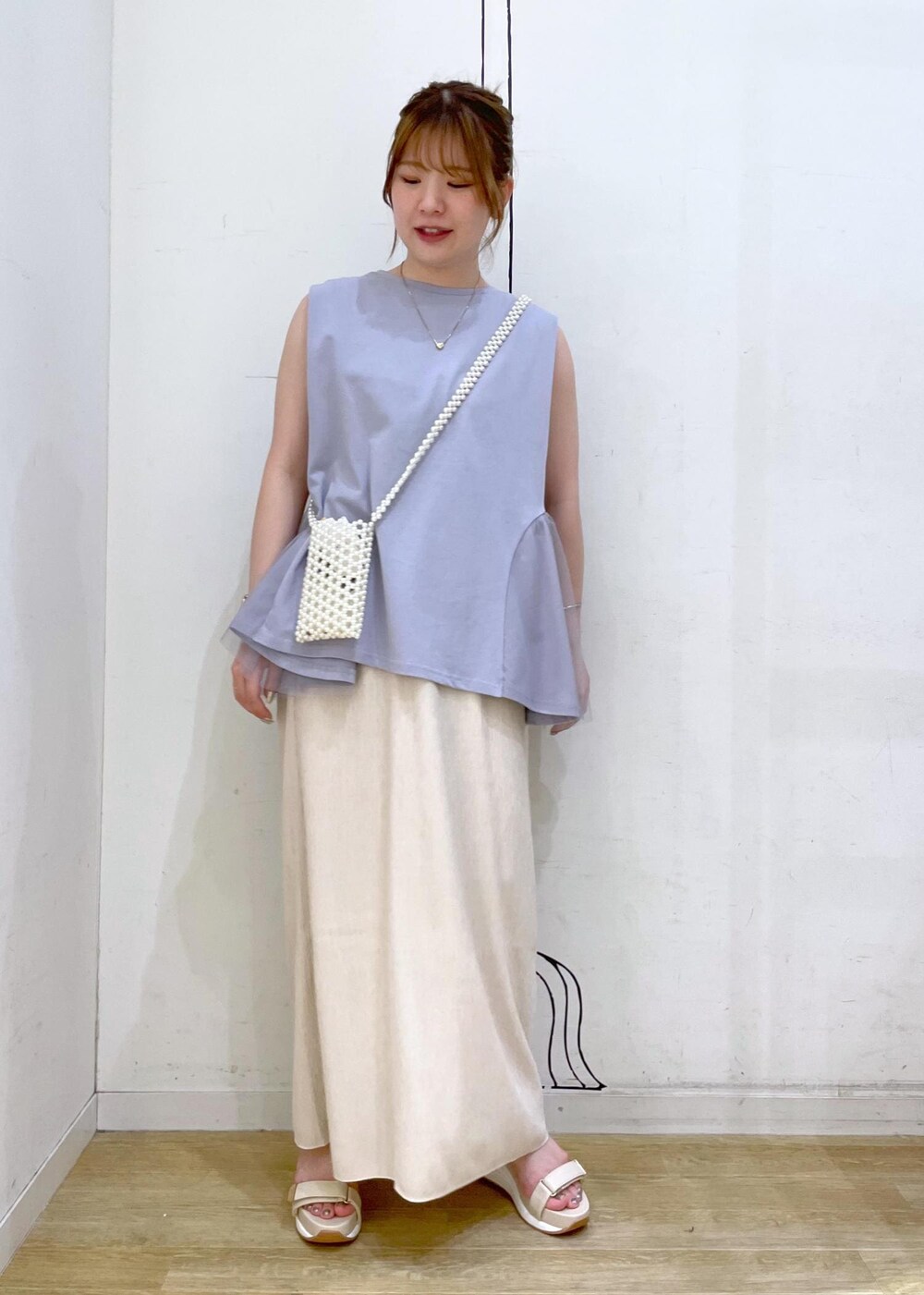 ベージュ系のスカート、ブルー系のTシャツ/カットソー、ホワイト系のサンダルを着用したレディースの夏コーディネートの4枚目の写真