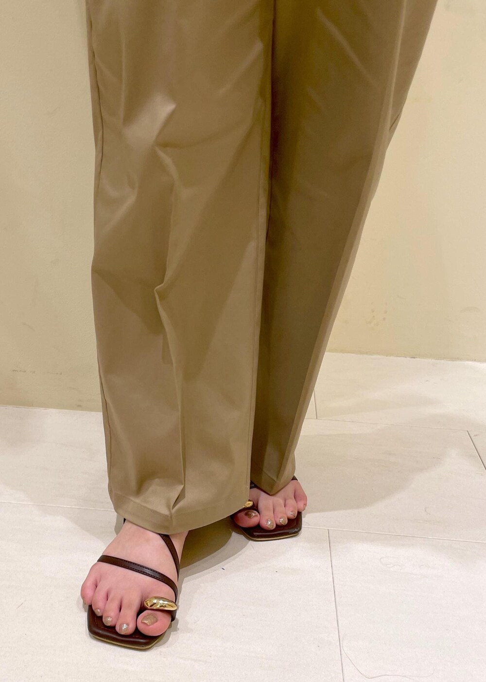 ベージュ系のチノパンツ、ブラウン系のサンダル、ブラック系のハンドバッグを着用したレディースの夏コーディネートの8枚目の写真