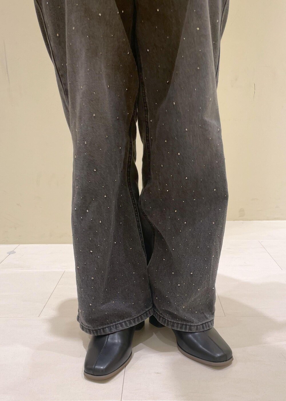 ホワイト系のタンクトップ、グレー系のベスト、ブラック系のブーツを着用したレディースの秋コーディネートの9枚目の写真