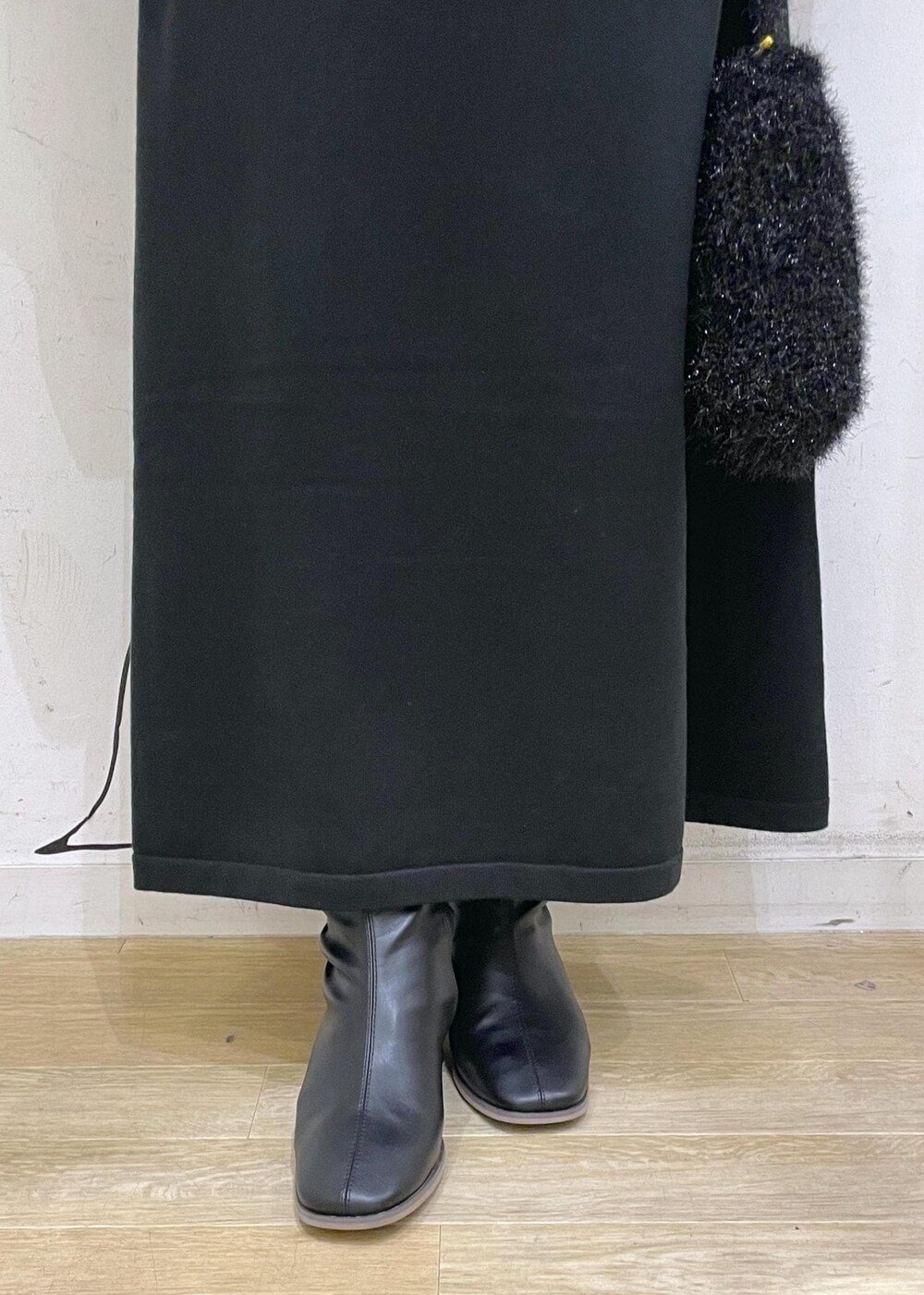 ブラック系のワンピース、グレー系のニット/セーター、ブラック系のブーツを着用したレディースの冬コーディネートの7枚目の写真