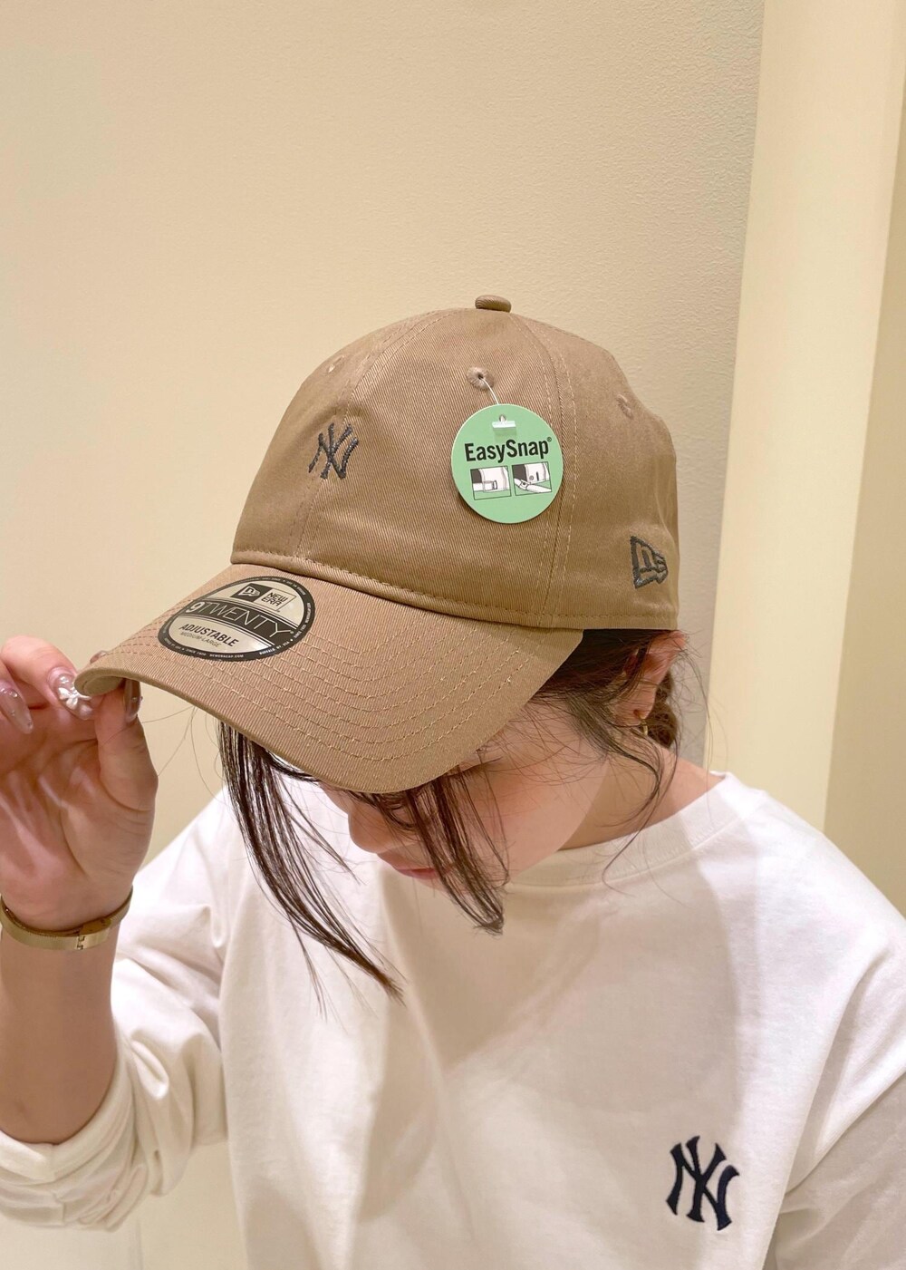 ホワイト系のシャツ/ブラウス、ホワイト系のTシャツ/カットソー、ベージュ系のスラックスを着用したレディースの秋コーディネートの9枚目の写真