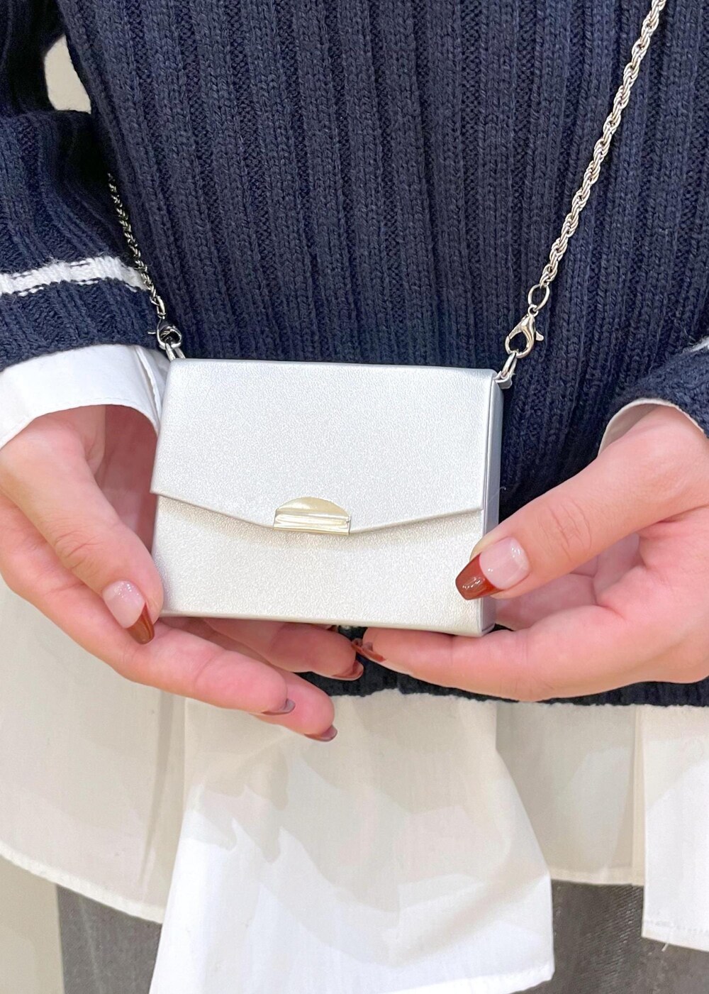 シルバー系のパンプス、ホワイト系のシャツ/ブラウス、ブルー系のニット/セーターを着用したレディースの秋コーディネートの7枚目の写真