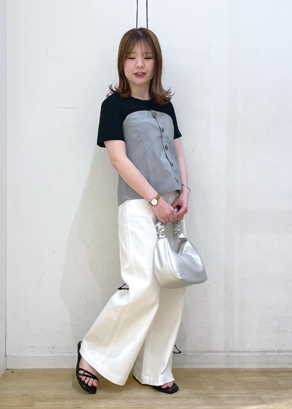ブラック系のTシャツ/カットソー、ブラック系のサンダル、ホワイト系のデニムパンツを着用したレディースの春コーディネートの4枚目の写真