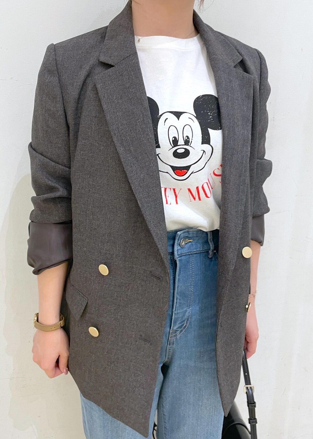 シルバー系のパンプス、ブルー系のデニムパンツ、ブラウン系のテーラードジャケットを着用したレディースの秋コーディネートの5枚目の写真