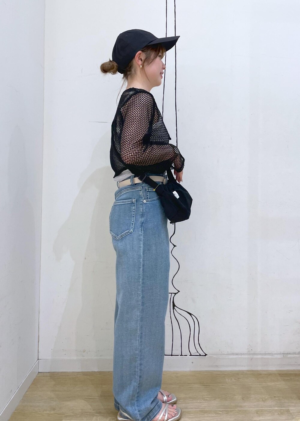 シルバー系のサンダル、ブラック系のショルダーバッグ、ホワイト系のタンクトップを着用したレディースの夏コーディネートの3枚目の写真