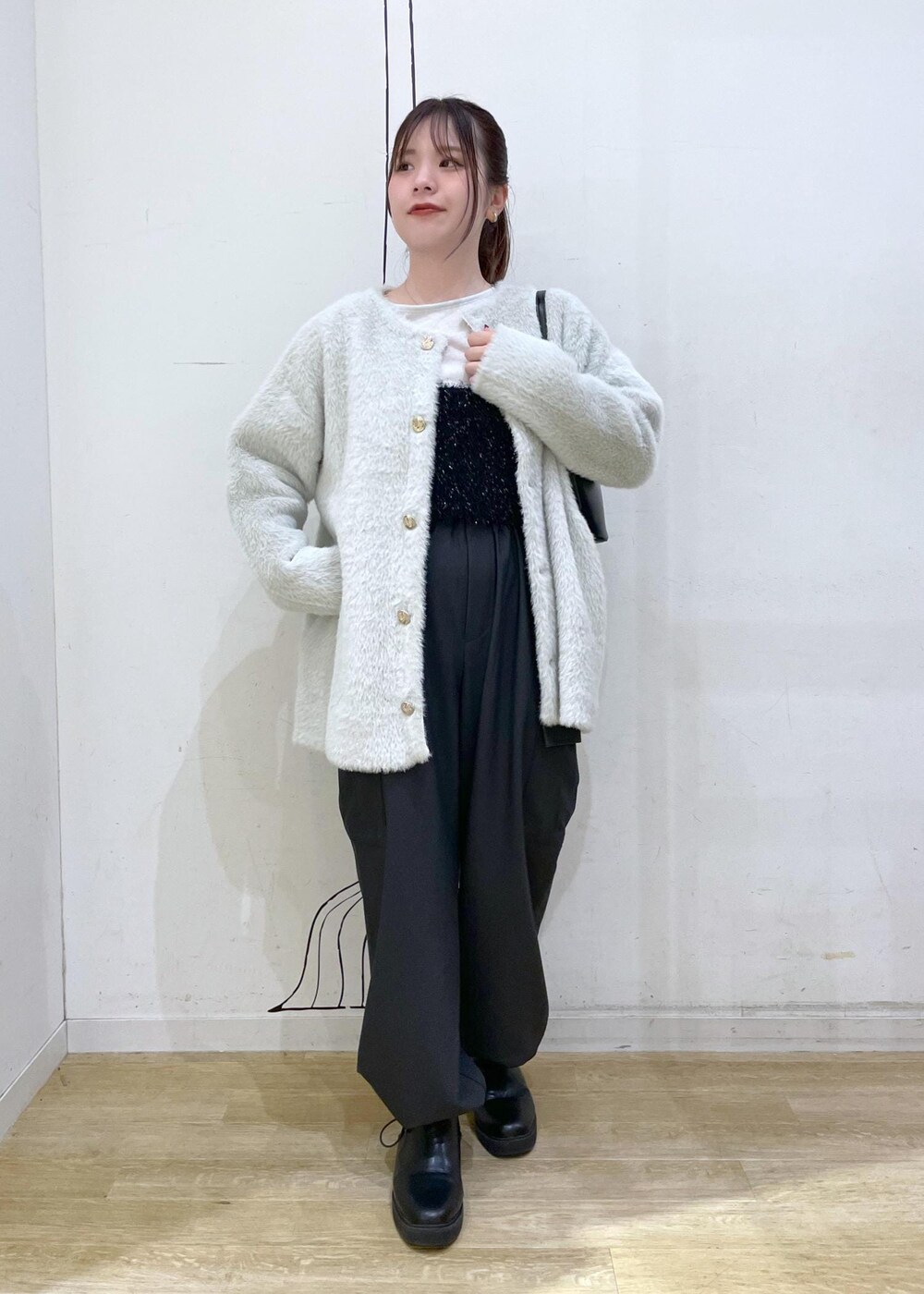 ホワイト系のTシャツ/カットソー、ブラック系のベスト、ブラック系のショルダーバッグを着用したレディースの秋コーディネートの4枚目の写真