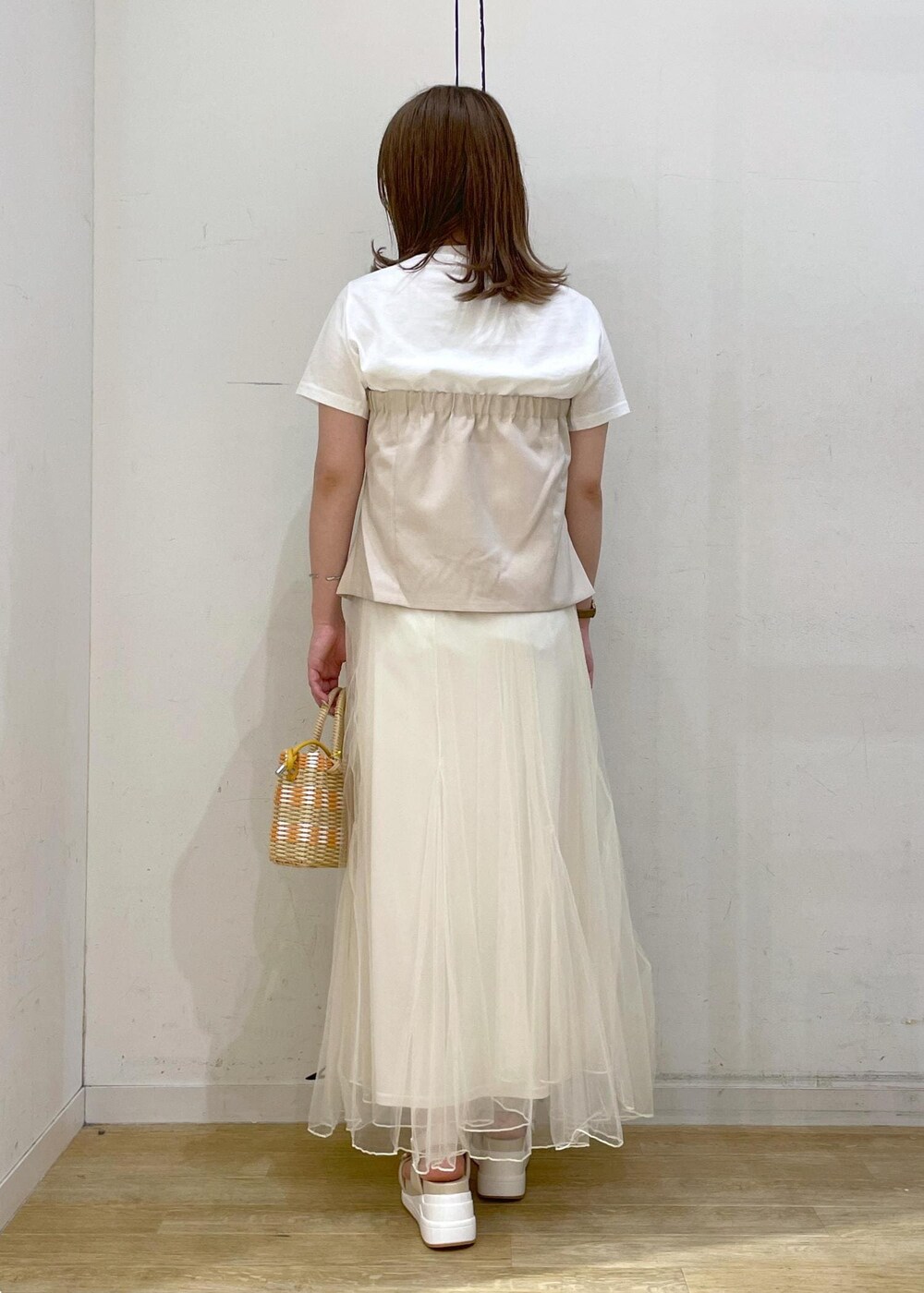 ホワイト系のスカート、ベージュ系のTシャツ/カットソー、ホワイト系のサンダルを着用したレディースの春コーディネートの2枚目の写真