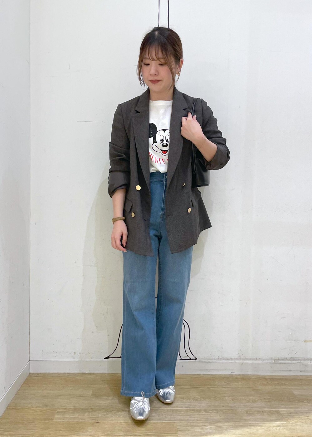 シルバー系のパンプス、ブルー系のデニムパンツ、ブラウン系のテーラードジャケットを着用したレディースの秋コーディネートの4枚目の写真