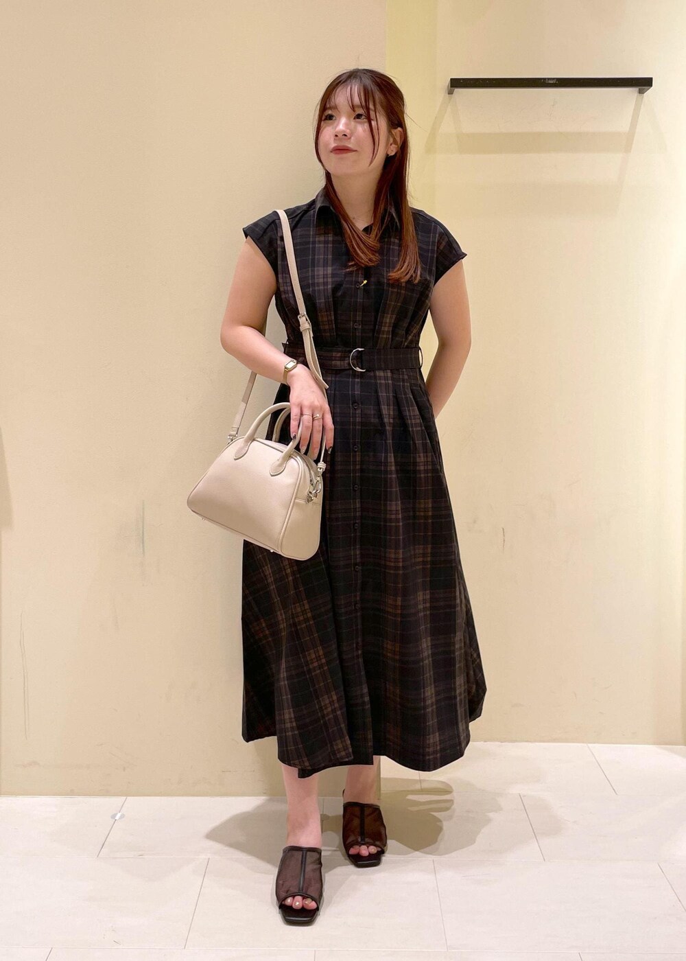 ブラック系のパンプス、ブラック系のワンピース、ベージュ系のボストンバッグを着用したレディースの夏コーディネートの10枚目の写真