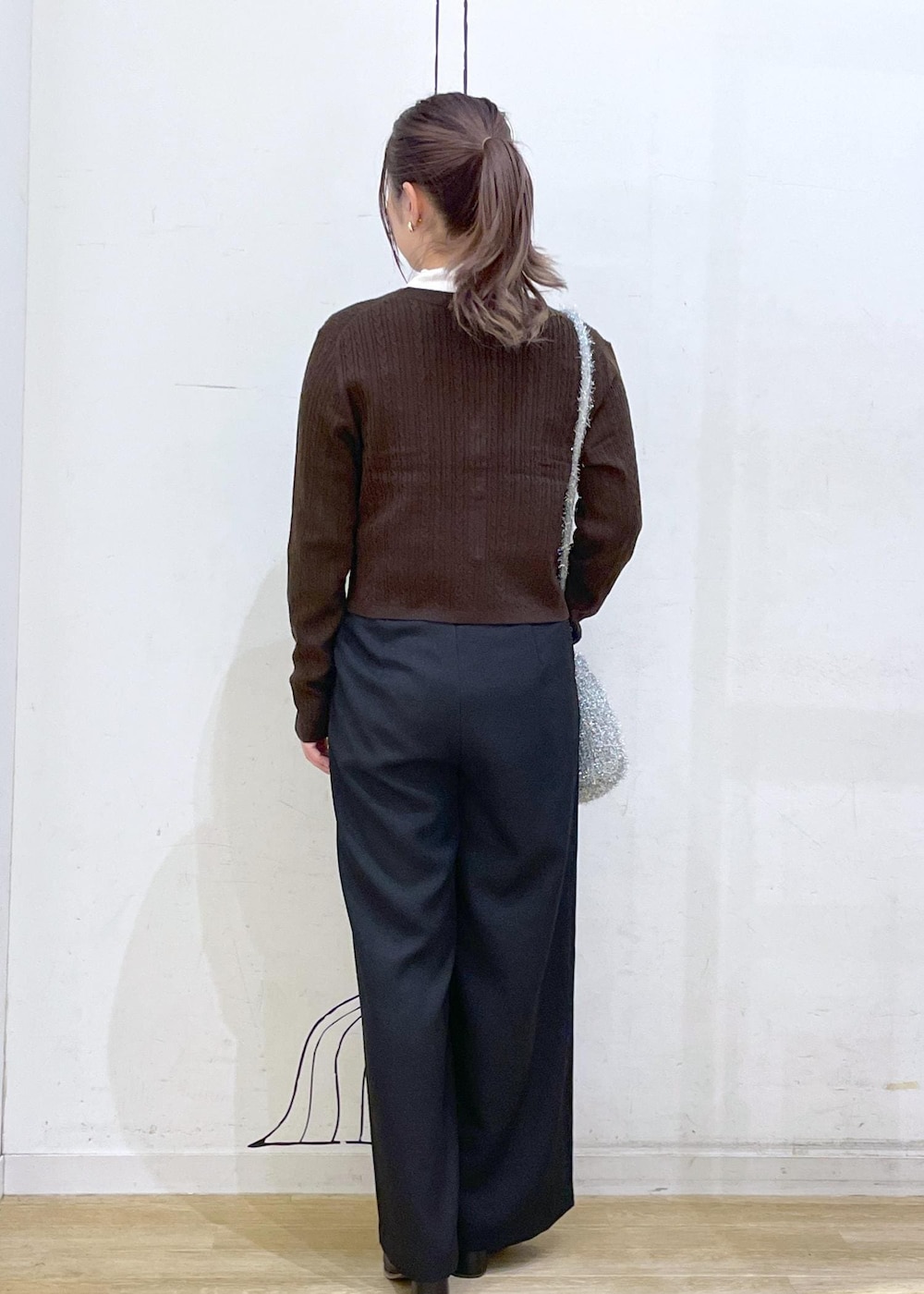 ホワイト系のTシャツ/カットソー、ブラック系のブーツ、ブラウン系のカーディガン/ボレロを着用したレディースの秋コーディネートの2枚目の写真