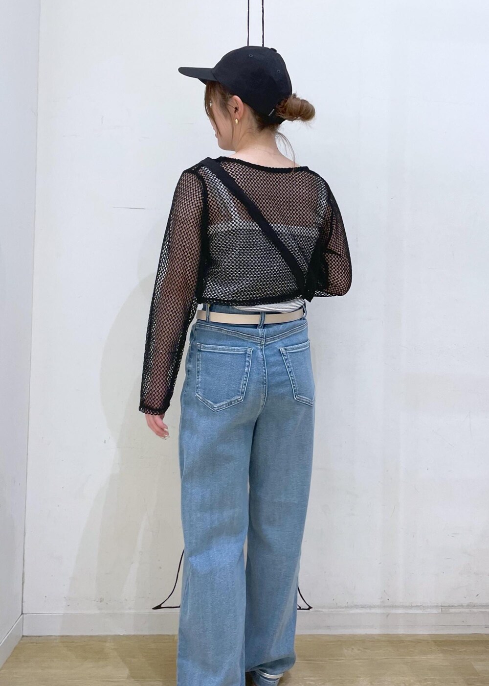 シルバー系のサンダル、ブラック系のショルダーバッグ、ホワイト系のタンクトップを着用したレディースの夏コーディネートの2枚目の写真