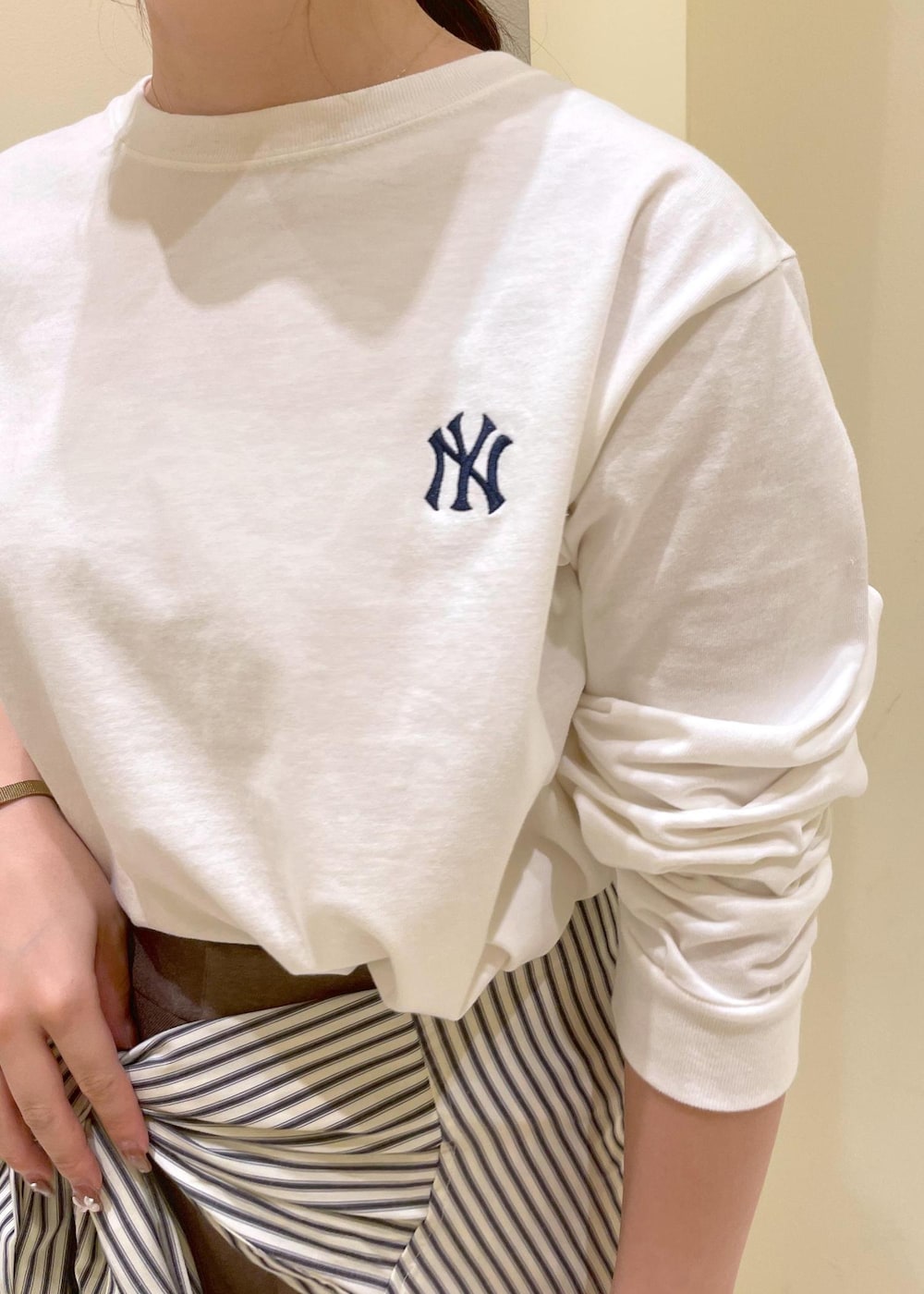 ホワイト系のシャツ/ブラウス、ホワイト系のTシャツ/カットソー、ベージュ系のスラックスを着用したレディースの秋コーディネートの6枚目の写真