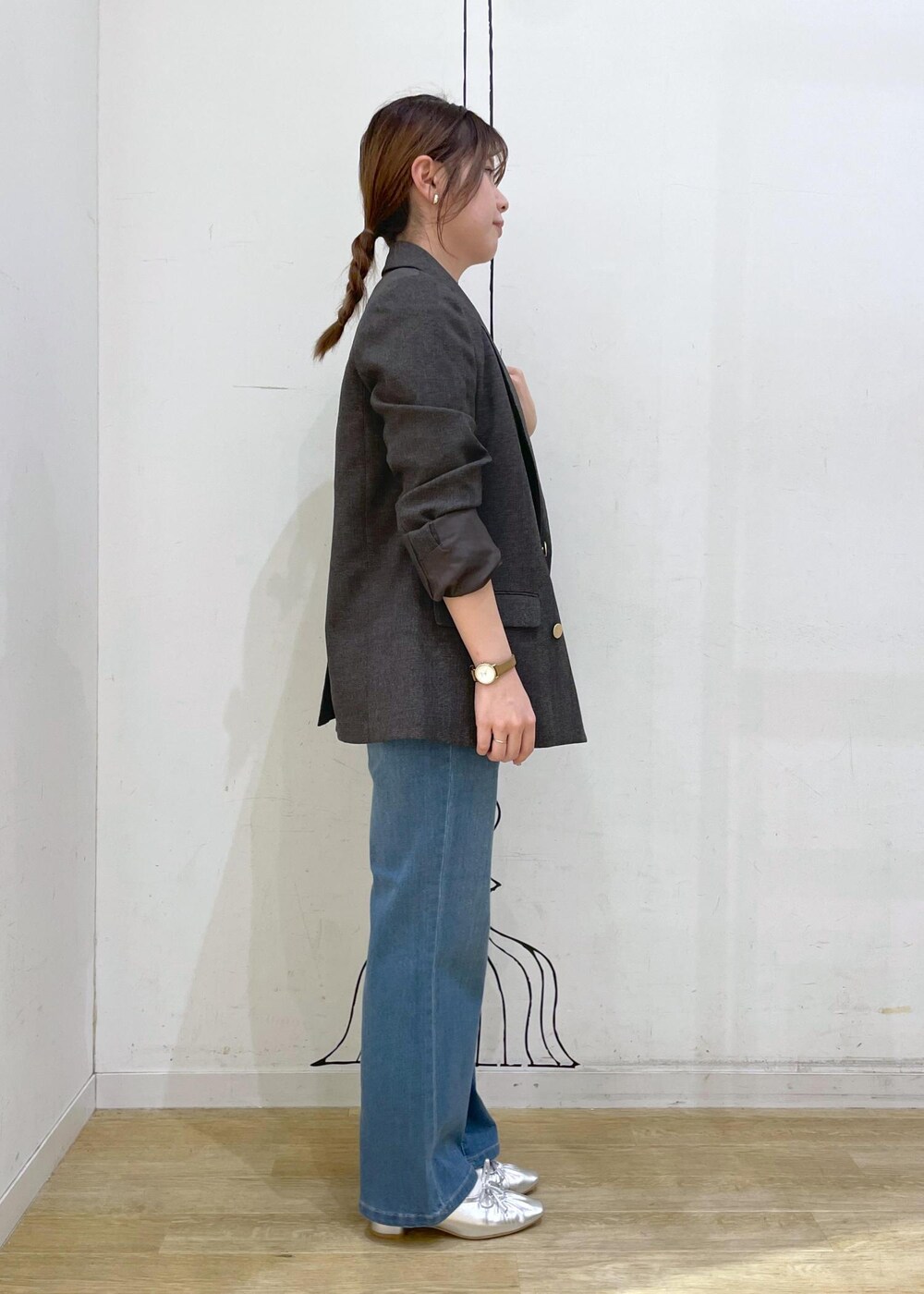 シルバー系のパンプス、ブルー系のデニムパンツ、ブラウン系のテーラードジャケットを着用したレディースの秋コーディネートの3枚目の写真