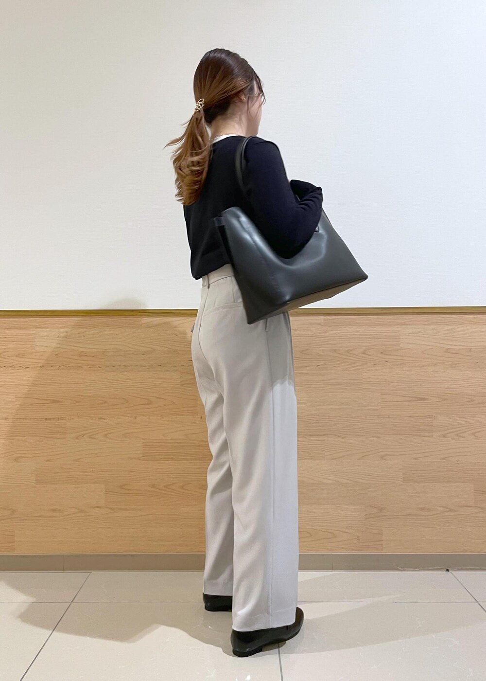 ブラック系のトートバッグ、ブラック系のパンプス、ブルー系のカーディガン/ボレロを着用したレディースの春コーディネートの3枚目の写真