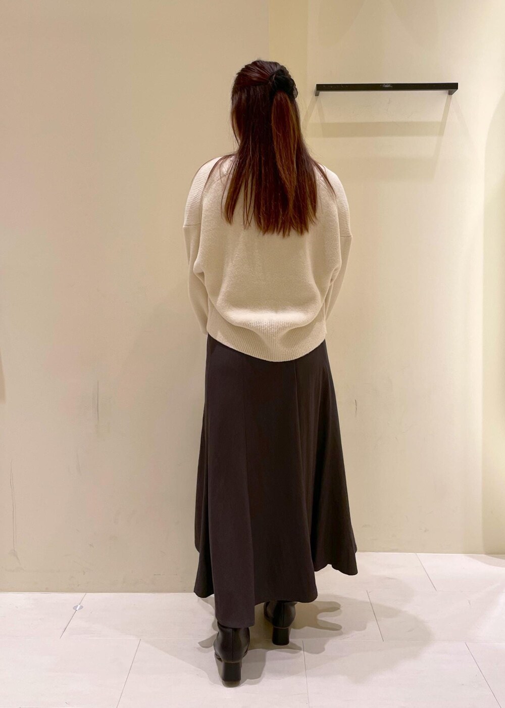 グレー系のスカート、ホワイト系のカーディガン/ボレロ、ホワイト系のTシャツ/カットソーを着用したレディースの秋コーディネートの2枚目の写真