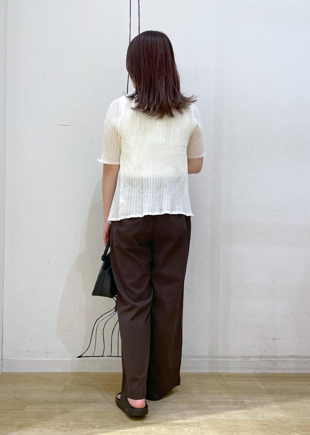 ブラック系のサンダル、ホワイト系のキャミソール、ブラック系のショルダーバッグを着用したレディースの夏コーディネートの2枚目の写真