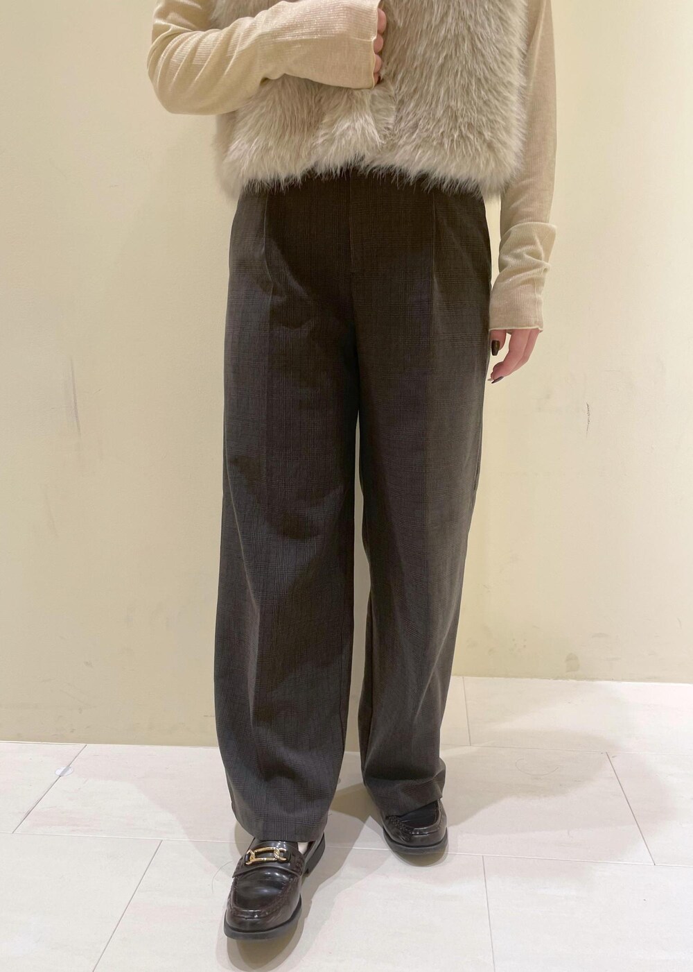 ブラック系のスラックス、ベージュ系のTシャツ/カットソー、ベージュ系のベストを着用したレディースの秋コーディネートの8枚目の写真