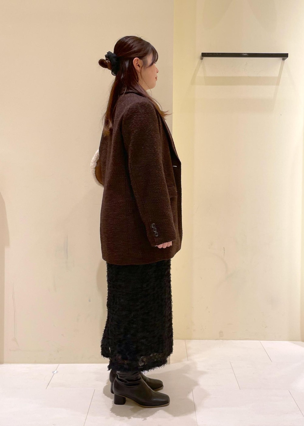 ホワイト系のカーディガン/ボレロ、ブラック系のブーツ、ブラウン系のテーラードジャケットを着用したレディースの秋コーディネートの2枚目の写真