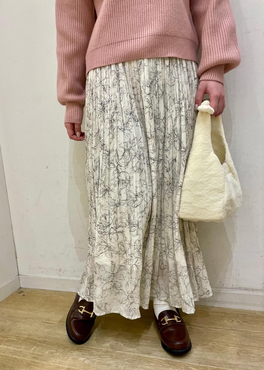 ホワイト系のスカート、ブラウン系のローファー、ホワイト系のショルダーバッグを着用したレディースの冬コーディネートの5枚目の写真