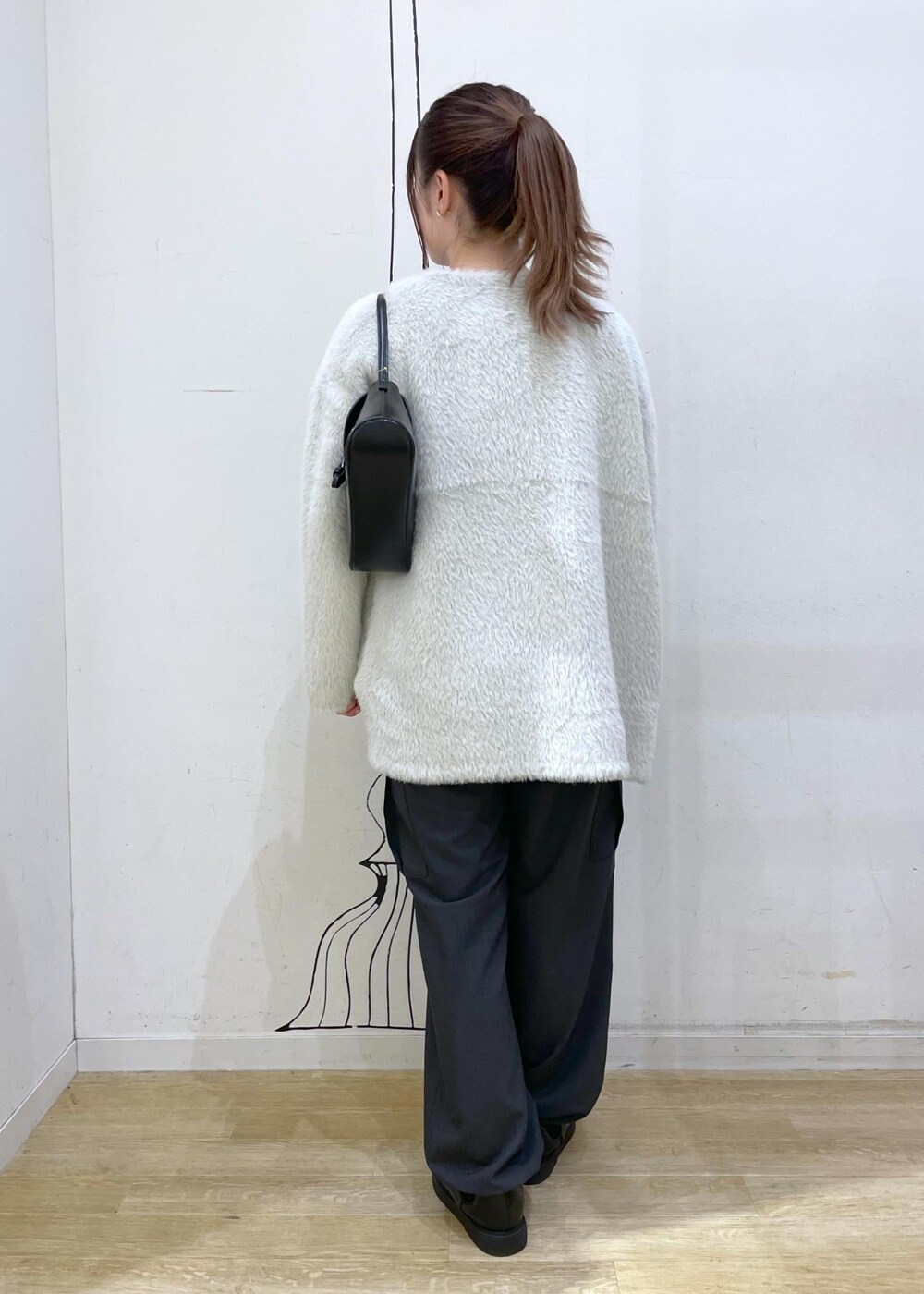 ホワイト系のTシャツ/カットソー、ブラック系のベスト、ブラック系のショルダーバッグを着用したレディースの秋コーディネートの2枚目の写真