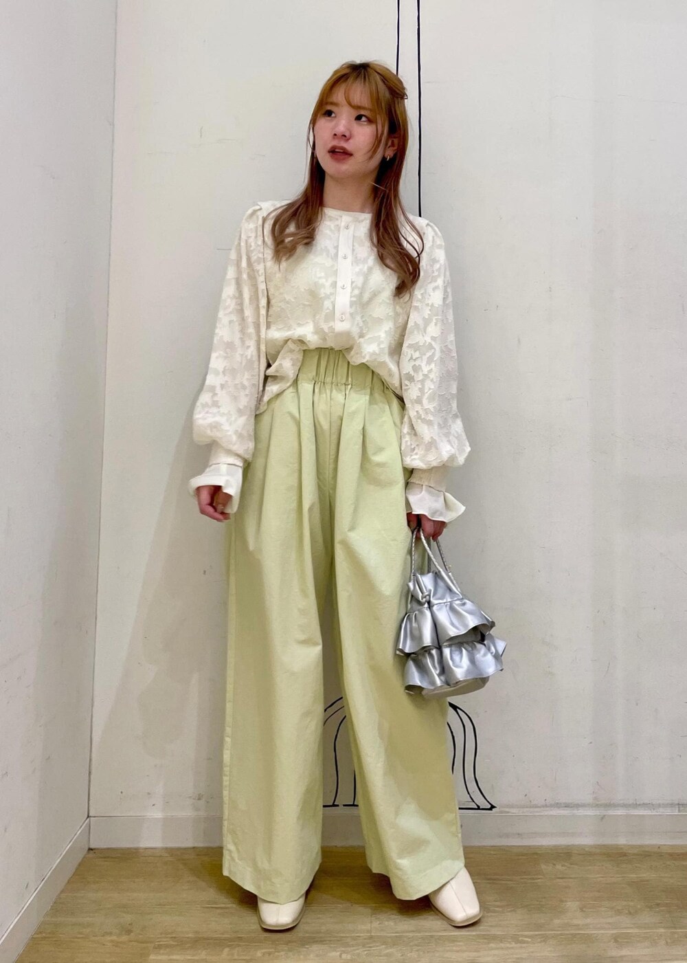 シルバー系のショルダーバッグ、ホワイト系のパンプス、イエロー系のその他パンツを着用したレディースの春コーディネートの9枚目の写真
