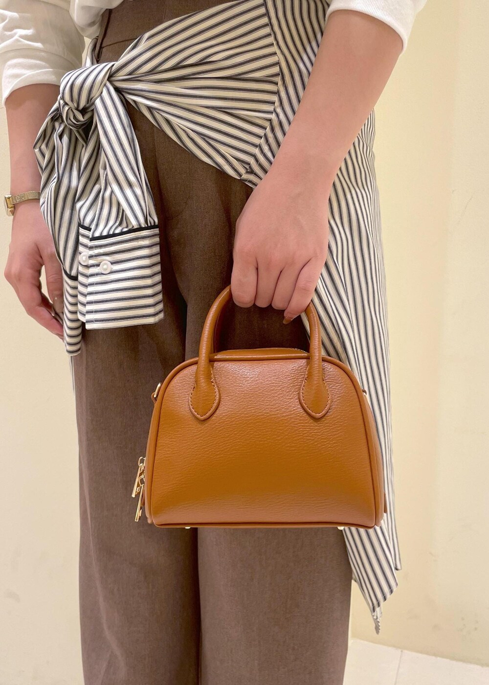 ホワイト系のシャツ/ブラウス、ホワイト系のTシャツ/カットソー、ベージュ系のスラックスを着用したレディースの秋コーディネートの10枚目の写真