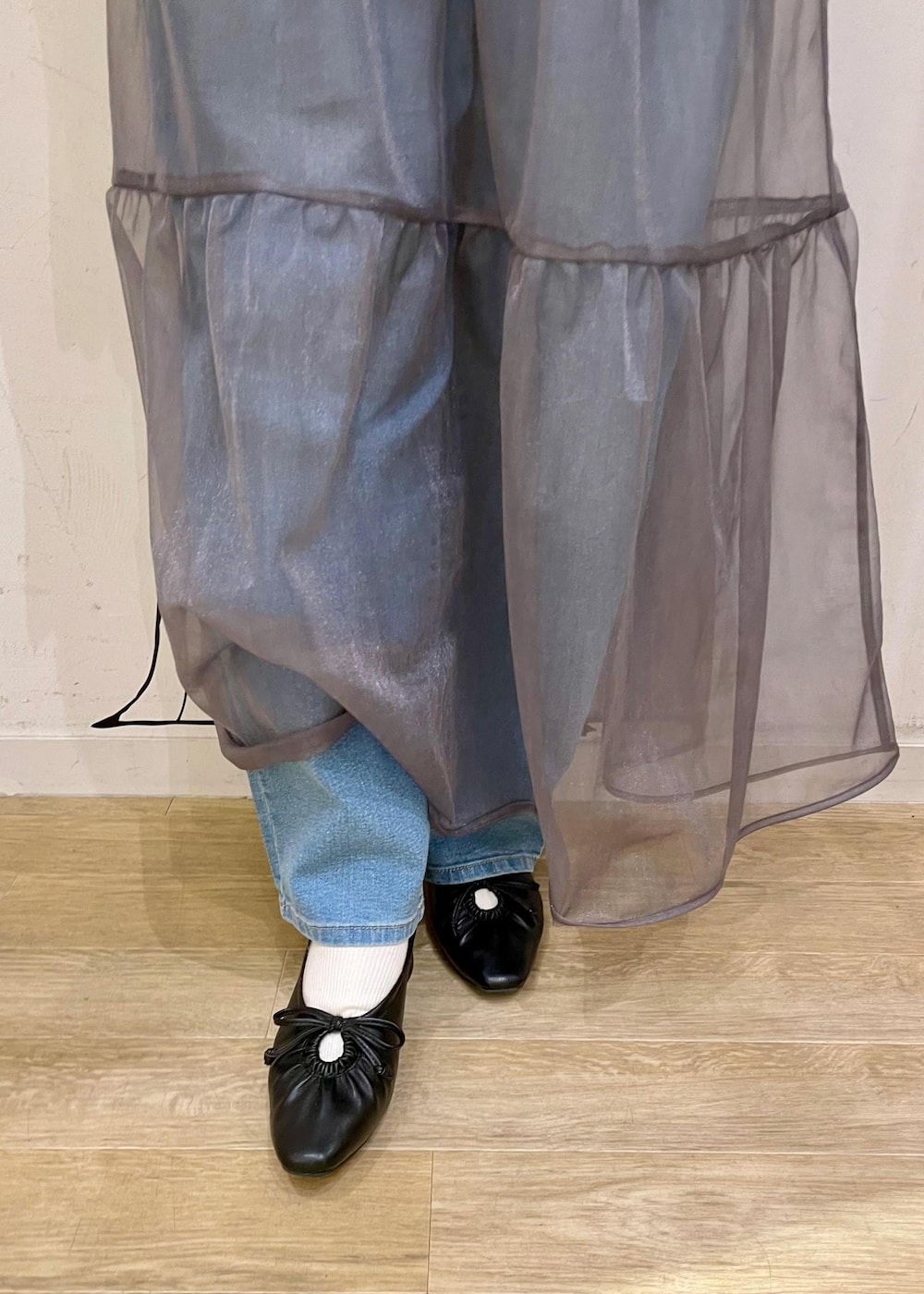 グレー系のショルダーバッグ、ブラック系のベスト、グレー系のニット/セーターを着用したレディースの春コーディネートの6枚目の写真