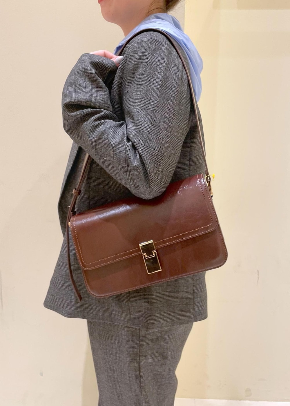 レッド系のショルダーバッグ、グレー系のテーラードジャケット、グレー系のスラックスを着用したレディースの秋コーディネートの8枚目の写真