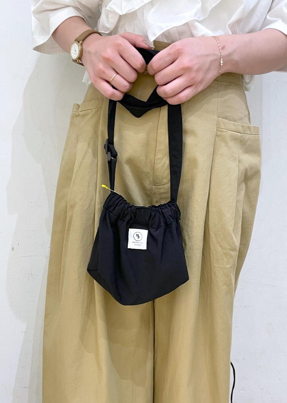 ブラック系のショルダーバッグ、ブラック系のサンダル、イエロー系のその他パンツを着用したレディースの夏コーディネートの7枚目の写真