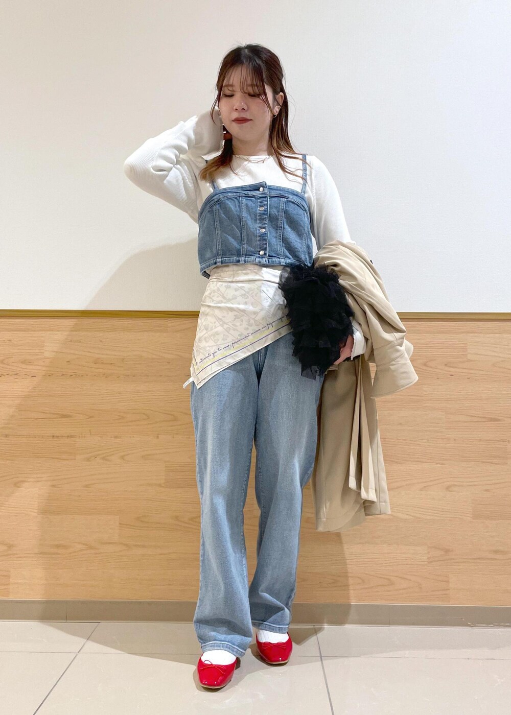 ブルー系のベスト、ホワイト系のニット/セーター、ベージュ系のトレンチコートを着用したレディースの春コーディネートの3枚目の写真