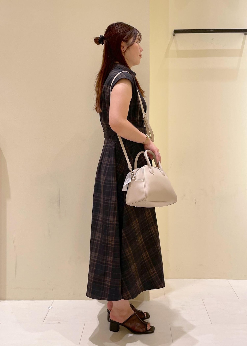 ブラック系のパンプス、ブラック系のワンピース、ベージュ系のボストンバッグを着用したレディースの夏コーディネートの3枚目の写真