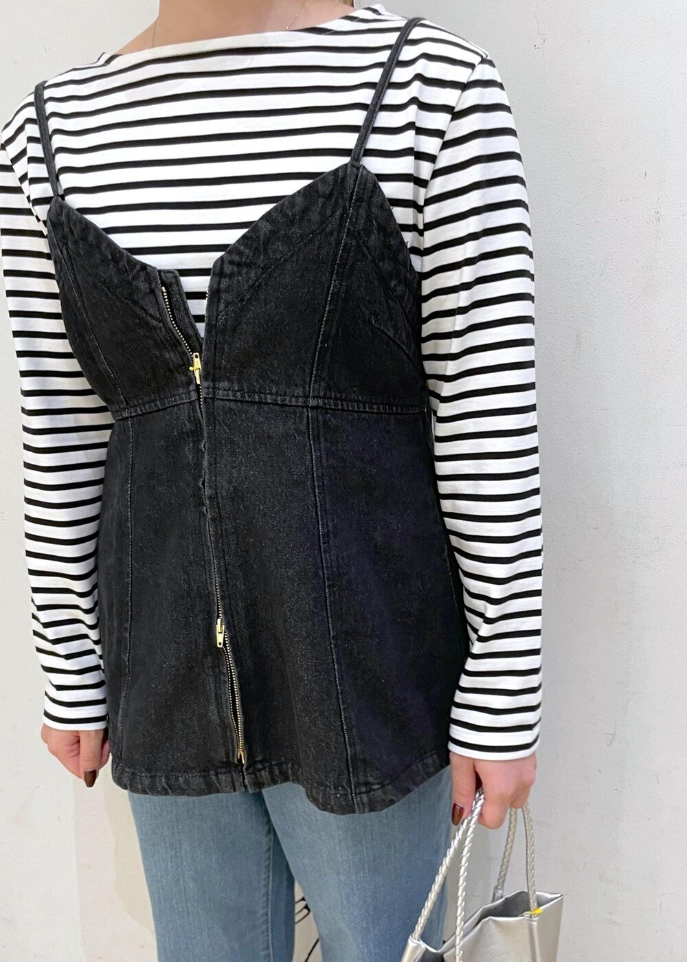 シルバー系のパンプス、ホワイト系のTシャツ/カットソー、ブラック系のベストを着用したレディースの秋コーディネートの5枚目の写真