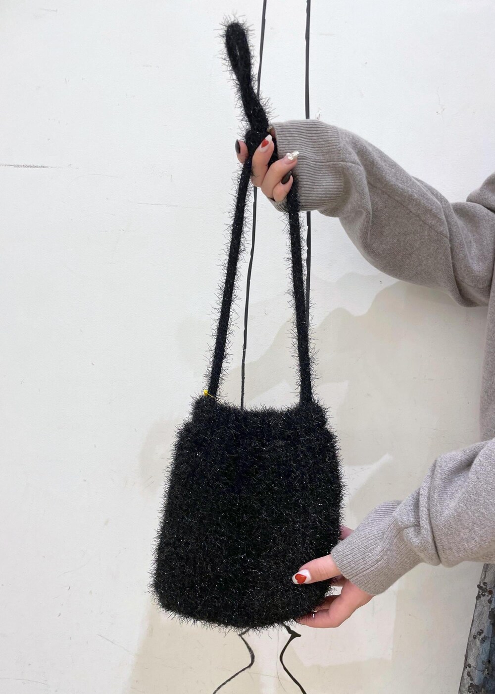 ブラック系のスカート、グレー系のニット/セーター、ブラック系のブーツを着用したレディースの秋コーディネートの8枚目の写真