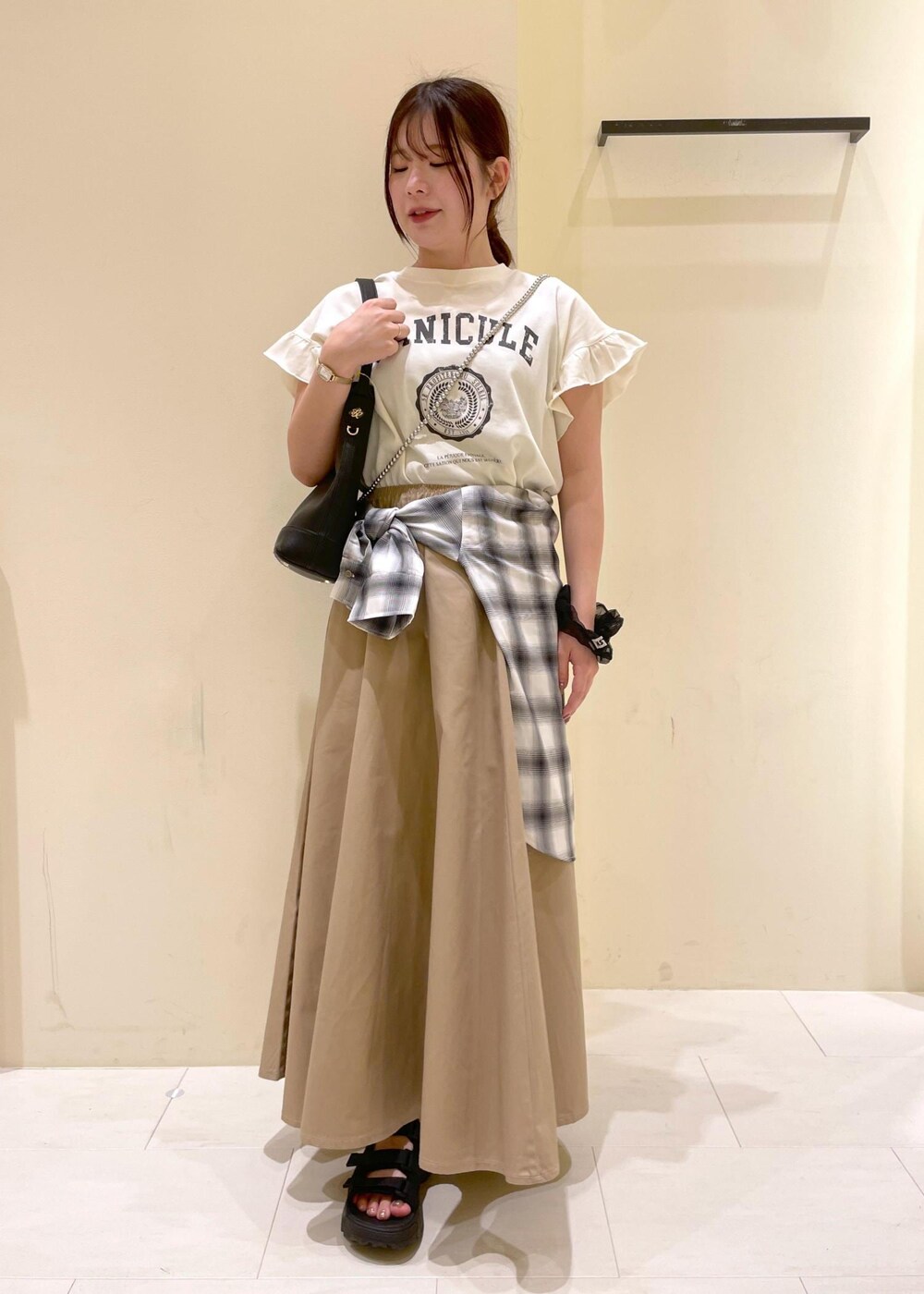 ブラック系のサンダル、ベージュ系のスカート、ホワイト系のシャツ/ブラウスを着用したレディースの夏コーディネートの4枚目の写真