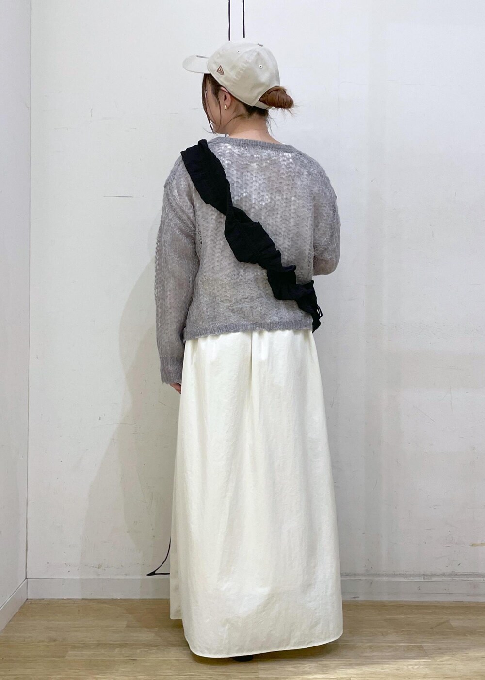 ブラック系のローファー、ホワイト系のスカート、グレー系のニット/セーターを着用したレディースの秋コーディネートの2枚目の写真