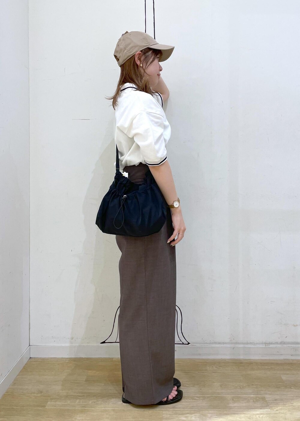 ブラウン系のその他パンツ、ブラック系のサンダル、ホワイト系のポロシャツを着用したレディースの春コーディネートの3枚目の写真