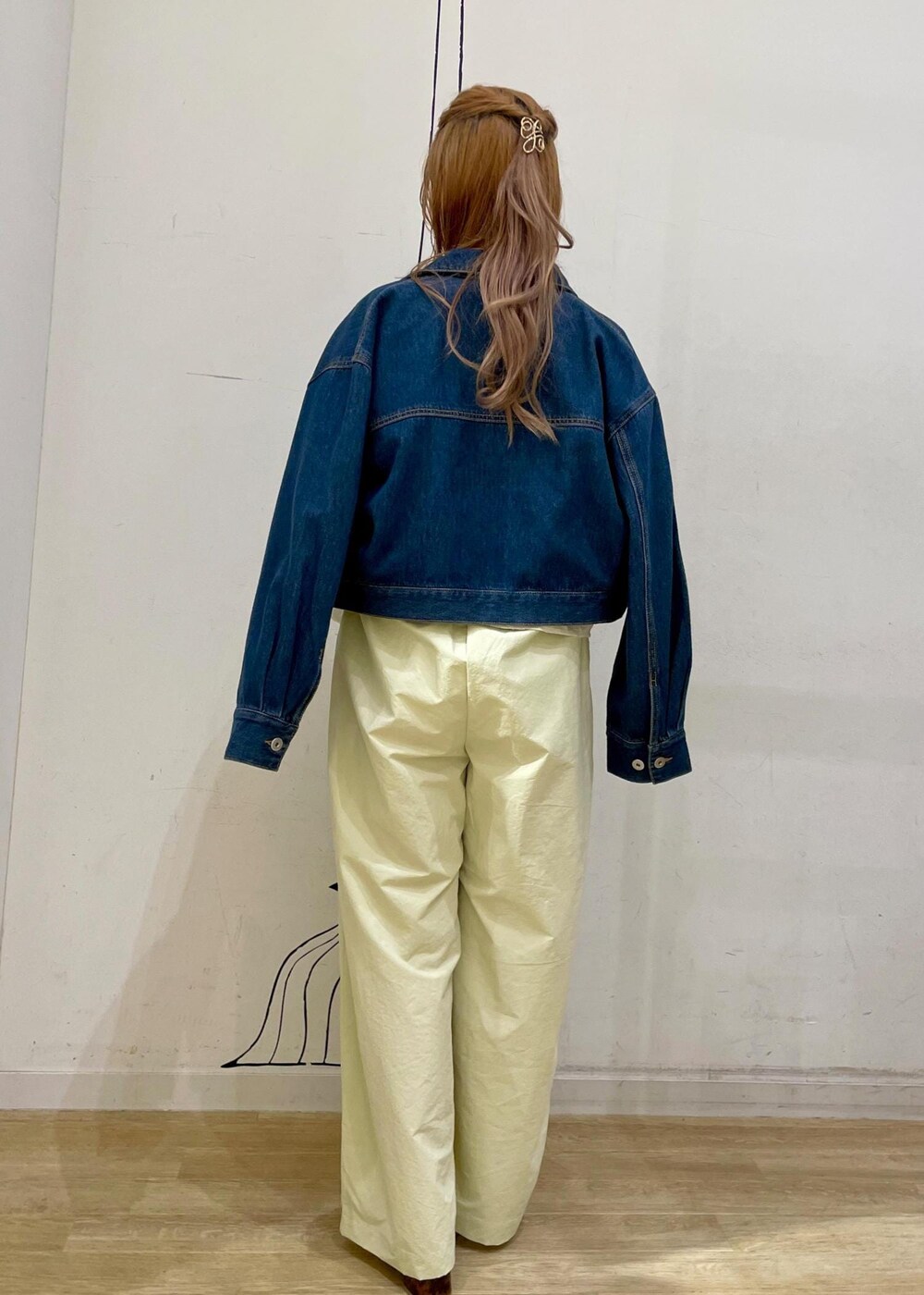 シルバー系のショルダーバッグ、ホワイト系のパンプス、ブルー系のデニムジャケットを着用したレディースの春コーディネートの2枚目の写真