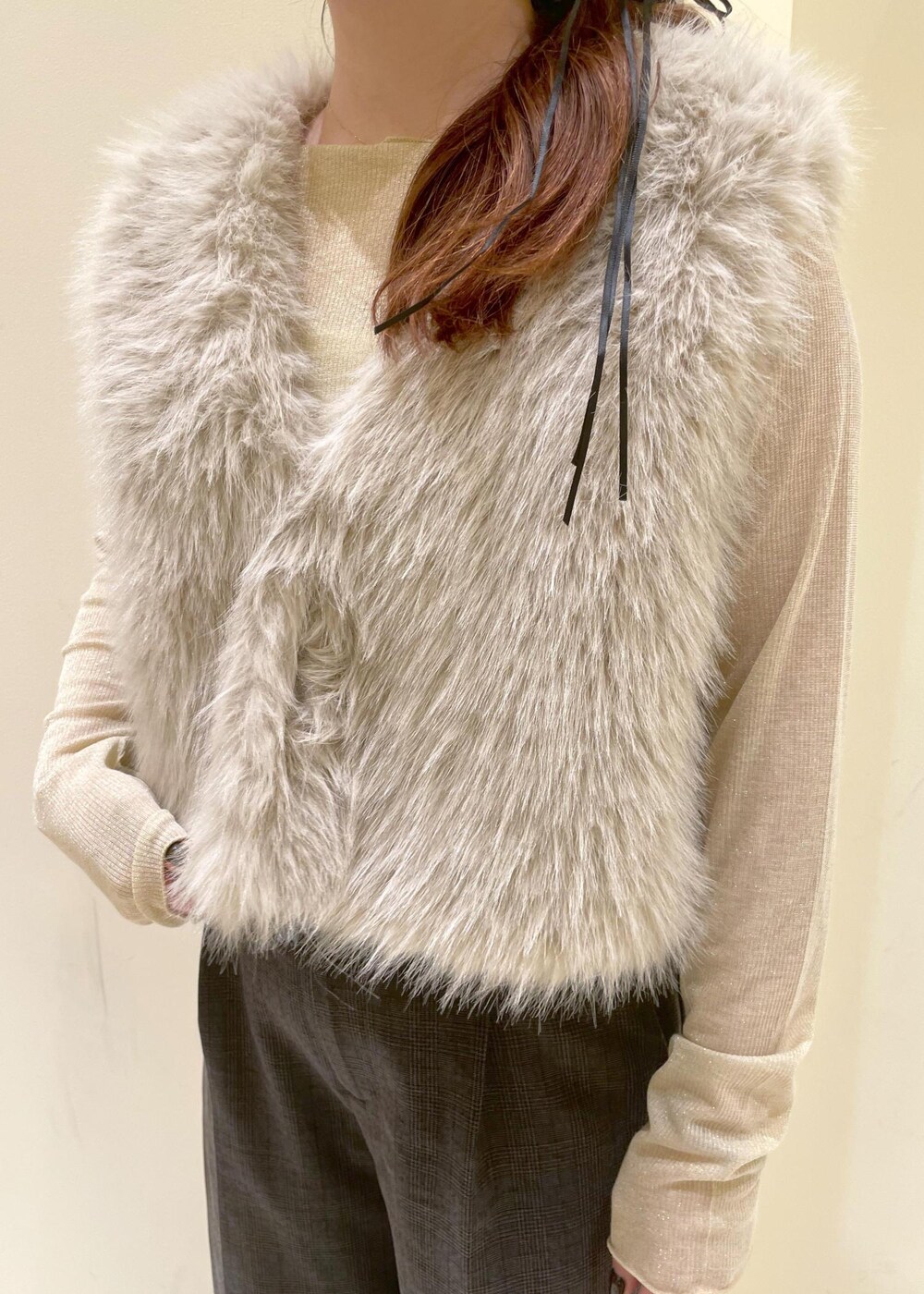 ブラック系のスラックス、ベージュ系のTシャツ/カットソー、ベージュ系のベストを着用したレディースの秋コーディネートの6枚目の写真