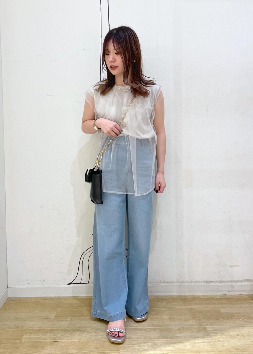 ブルー系のデニムパンツ、シルバー系のサンダル、グレー系のTシャツ/カットソーを着用したレディースの夏コーディネートの4枚目の写真