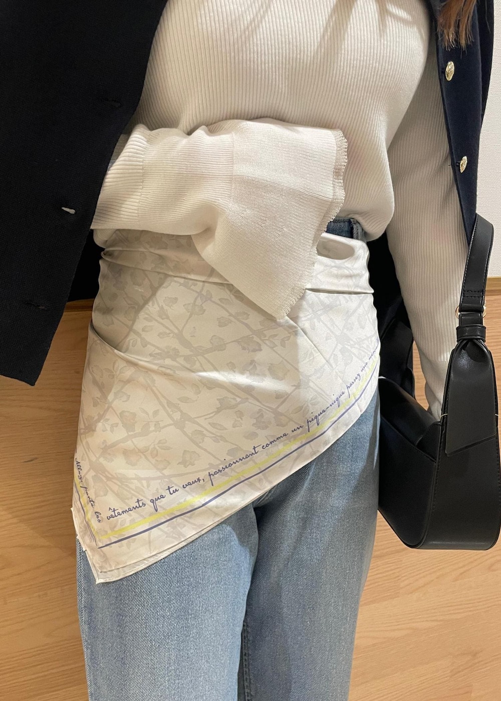 ブルー系のカーディガン/ボレロ、ホワイト系のニット/セーター、ブラック系のハンドバッグを着用したレディースの春コーディネートの7枚目の写真