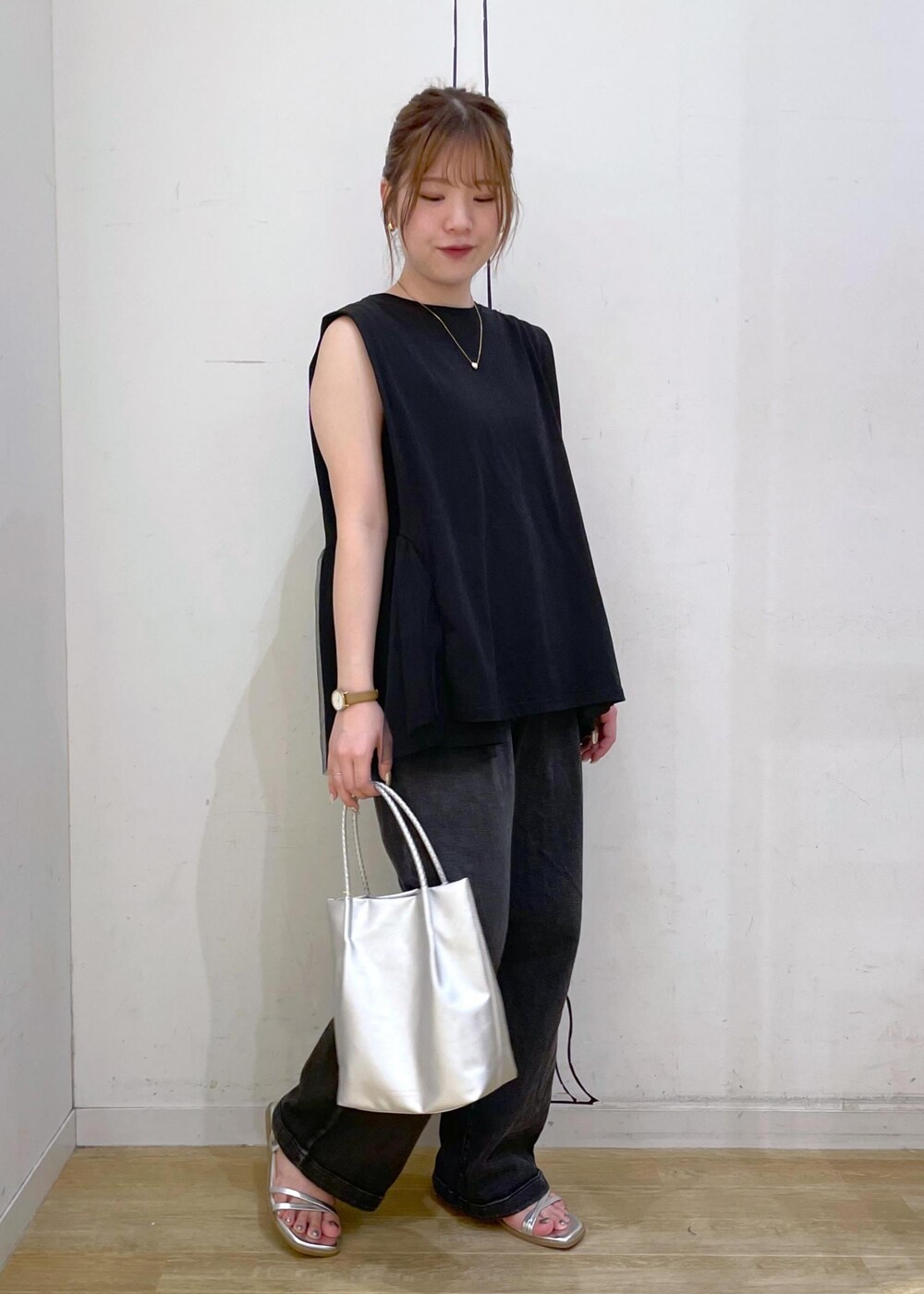 ブラック系のTシャツ/カットソー、シルバー系のサンダル、ブラック系のデニムパンツを着用したレディースの夏コーディネートの10枚目の写真